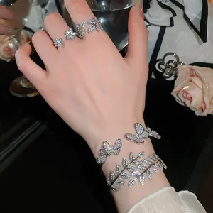 Elegant silver-toned zircon butterfly and leaf ring and bangle jewelry set shown on a hand