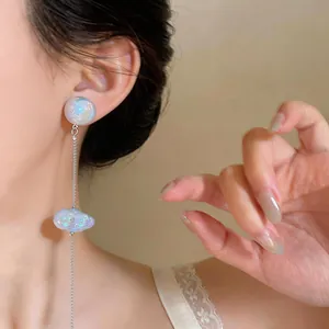 Primo piano di eleganti orecchini a nappa con nuvole d'argento e perle iridescenti.