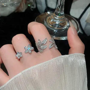 Close-up detail shot of sparkling zircon leaf and flower rings set for a luxury look.
