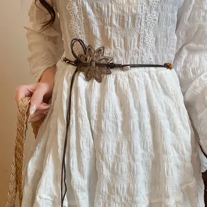 Nahaufnahme des handgefertigten braunen Flechtgürtels mit einer Vintage-Blumenschnalle