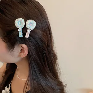 Pinces à cheveux en forme de donut doux avec strass en cœur sur les cheveux d'un modèle.