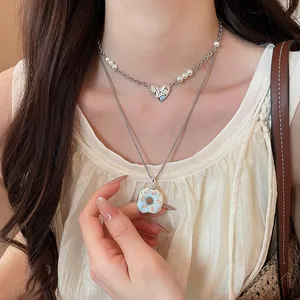 Gros plan du collier avec pendentif donut sucré et cœur porté par un mannequin asiatique