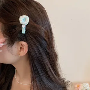 Gros plan d'une pince à cheveux donut sucré avec pendentif cœur.