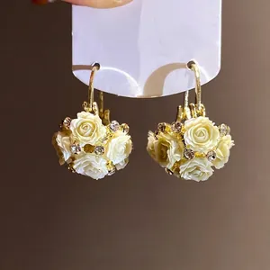 Elegante Creolen mit Harzblumen, funkelnden Strasssteinen und vergoldeten Metallelementen