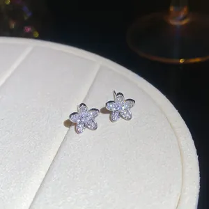 Macro view of sparkling five-petal zircon flower stud earrings in a silver finish