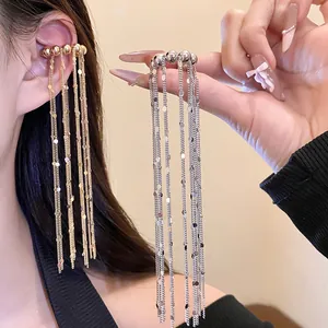 Detailansicht eleganter langer Quasten-Ohrklemmen in Gold und Silber an einem Model