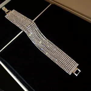 Detalle macro de una pulsera ancha de varias filas con diamantes de imitación sobre terciopelo