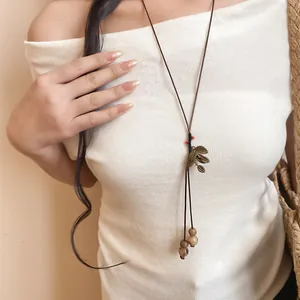 Gros plan d'un long collier fait main de style chinois moderne avec des graines de bodhi