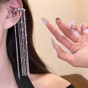 Nahaufnahme eines eleganten silbernen Ohrclips mit langen, feinen Quastenketten
