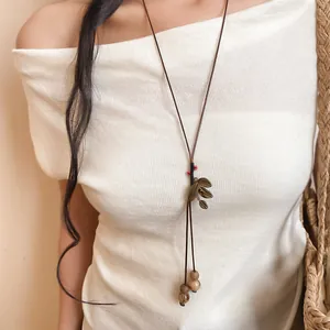 Vue détaillée d'un collier long ethnique fait main avec des graines de Bodhi sur un modèle