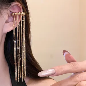 Nahaufnahme eines goldenen Earcuffs mit langen Fransen und eleganten Ketten-Details.