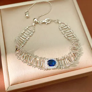 Vista macro detallada de una elegante pulsera de plata calada con circonita azul central