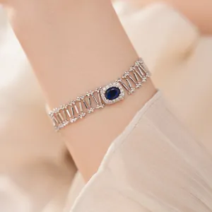 Detalle de pulsera calada de lujo con circonita azul ovalada y detalles brillantes