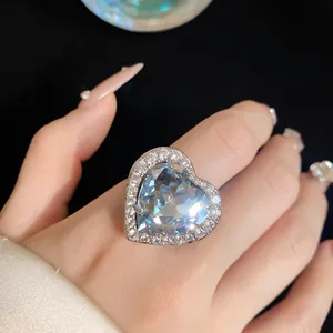 Detailed close-up of a luxury heart-shaped blue zircon ring with sparkling diamond pavé