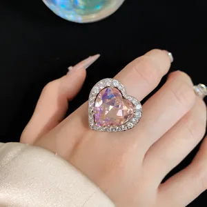 Close-up macro detail of a sparkling pink heart-shaped zircon ring with crystal pavé setting.