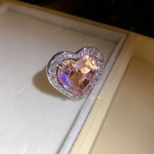 Detailed macro view of a sparkling heart-shaped pink zircon ring with elegant halo setting