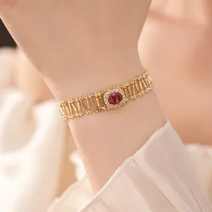 Primer plano detallado de una pulsera vintage de oro hueco con piedra de circón rojo