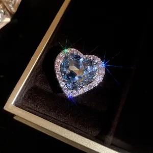Detailed close-up of a sparkling heart-shaped blue zircon ring with diamond halo