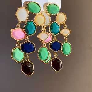 Macro view of vintage style multi-colored resin stone tassel drop earrings in gold setting