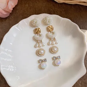 Macro view of a 4-pair elegant jewelry set featuring pearl clusters and bow-knot studs
