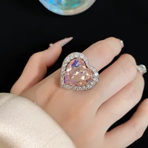 Close-up view of an elegant pink heart-shaped zircon ring featuring pavé crystal accents