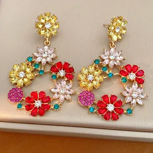 Colorful rhinestone flower wreath earrings with gold-tone finish on a luxury display box.