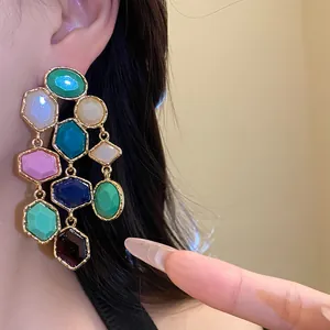 Close-up of vintage resin tassel earrings with colorful faceted stones