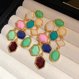 Close-up of vintage multi-color resin tassel earrings in a cream jewelry box tray