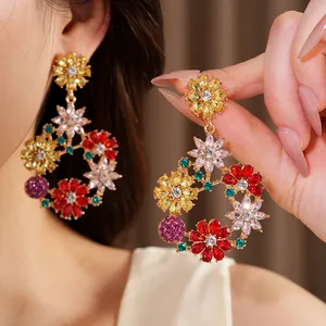 Detailed macro view of colorful rhinestone flower wreath drop earrings on a model