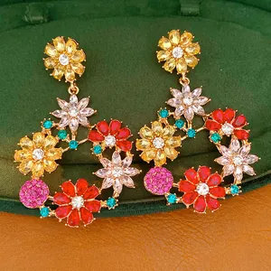 Macro view of vintage multi-color rhinestone floral earrings in a green velvet jewelry box