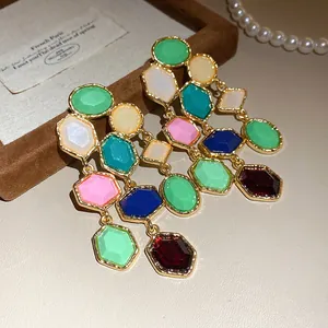 Close-up of vintage multi-color resin tassel earrings with gold-plated geometric frames