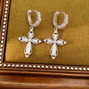 Vue détaillée de boucles d'oreilles croix argentées avec incrustations