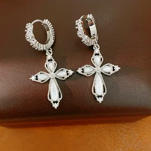 Gros plan détaillé sur des boucles d'oreilles croix élégantes avec pierres blanches