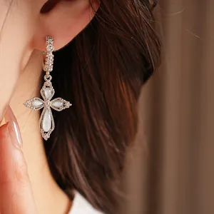 Gros plan détaillé d'une boucle d'oreille élégante à fleurs de zircon portée.