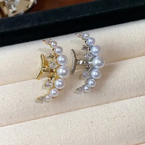 Gros plan sur des bagues d'oreille lune élégantes avec perles et zircons en or et argent