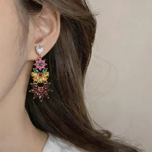 Detailed view of vintage-style multi-color floral tassel earrings worn by an elegant model
