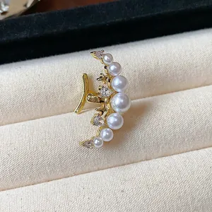 Détail du bijou d'oreille lune plaqué or 18k avec perles blanches et éclats de zircons
