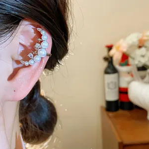 Détail d'un ear cuff lune avec perles et zircons porté sur le cartilage