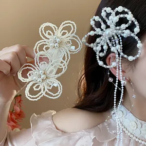 Dettaglio di un elegante fermaglio per capelli a fiore di perle con lunghe nappe di perle.