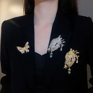 Vintage style metal anatomical heart and butterfly brooches worn on a black blazer jacket