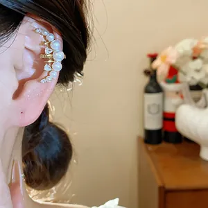 Gros plan d'un élégant ear cuff lune plaqué or avec perles blanches et zircons brillants