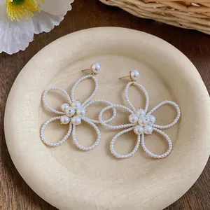 Orecchini a lobo francesi con perle a forma di fiore e design traforato.