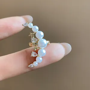 Détail en gros plan de l'élégante boucle d'oreille manchette lune avec perles et zircon.