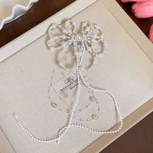 Dettaglio dell'elegante fermaglio a fiocco con perle e lunghe nappe di perline