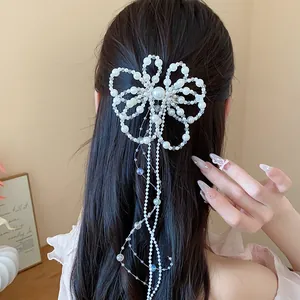 Dettaglio dell'elegante fermaglio per capelli a fiore di perle con lunga nappina su capelli