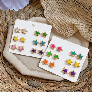 Detailed view of colorful star stud earrings displayed on cards with summer props.