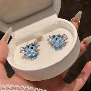 Dettaglio degli orecchini a clip a forma di orso in resina blu con ali di zircone