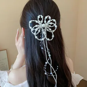 Dettaglio fermaglio capelli fiori e perle con lunghe nappe in stile francese chic.