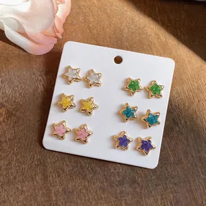 Set of six pairs of colorful star-shaped stud earrings presented on a white card