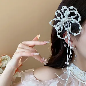 Dettaglio laterale di un elegante fermaglio per capelli a fiore di perle con nappe